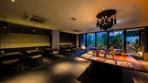 A modern restaurant with a long counter, booths, and a view of the outdoors.