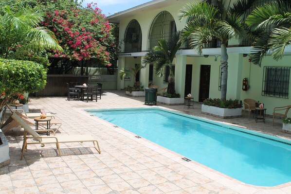 Alberca al aire libre y camastros 