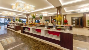 Montaje de bufé con diversos alimentos y plantas decorativas.