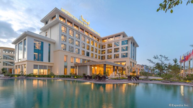 Un hotel moderno con una piscina grande y un área de estar al aire libre.