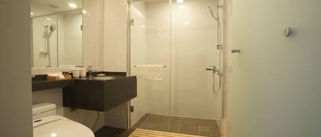 A modern bathroom with a glass-enclosed shower, a white toilet, and a dark-toned vanity.