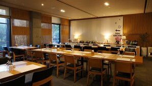 A conference room with multiple tables and chairs, a kitchen area, and a sign indicating the location of the KIKO PUB. - IlleInn Hotel (Seogwipo)