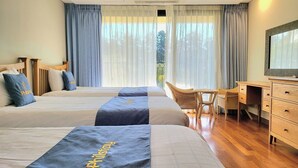 A hotel room with two beds, a desk, and a chair. - IlleInn Hotel (Seogwipo)