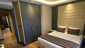 Un dormitorio moderno con una cama grande, suelo de madera y armarios empotrados.