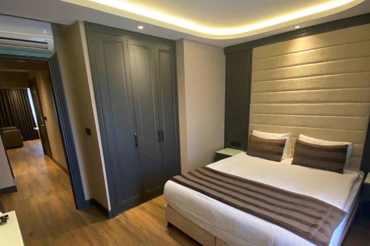 Un dormitorio moderno con una cama grande, suelo de madera y armarios empotrados.