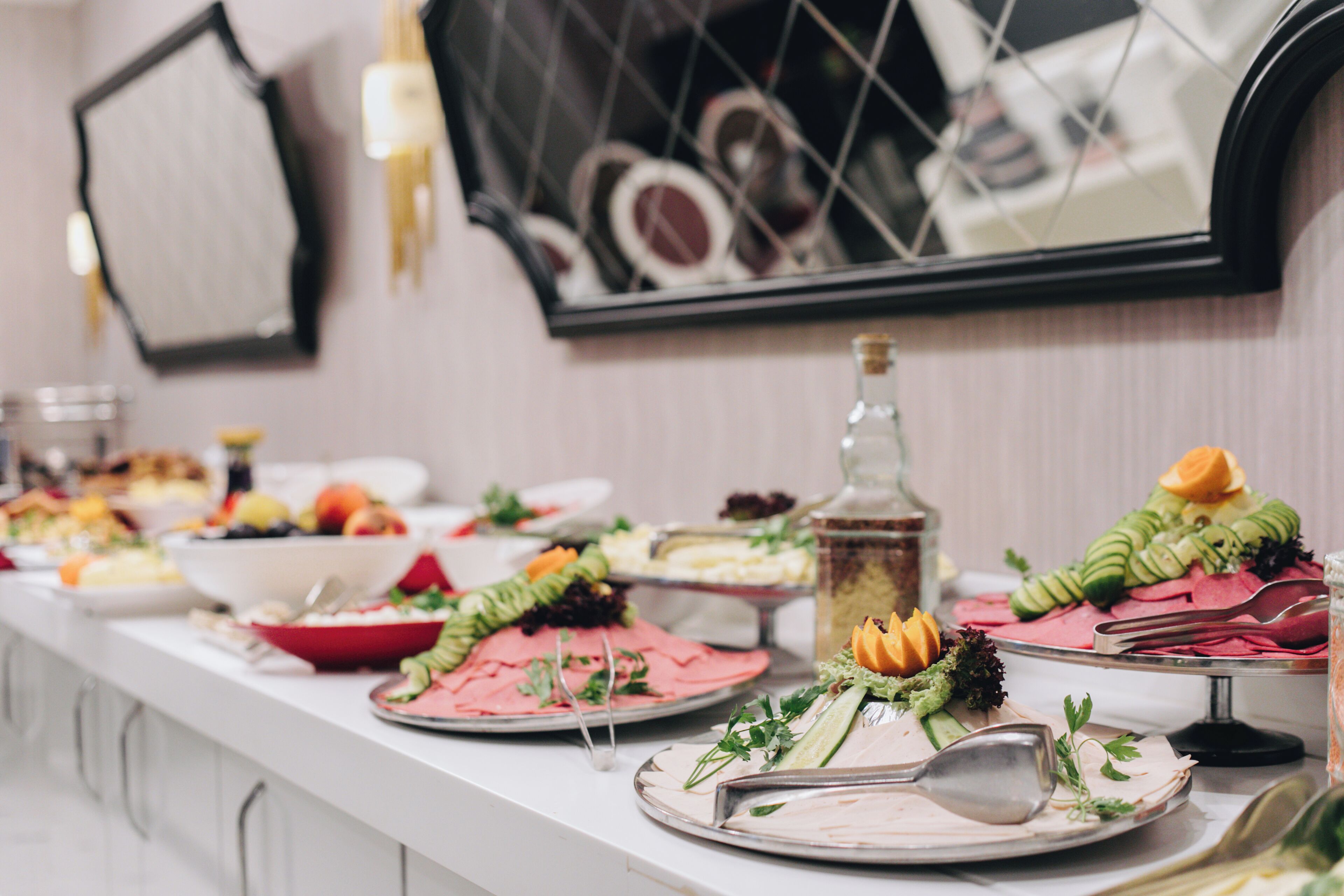 A buffet table with various food items and utensils.