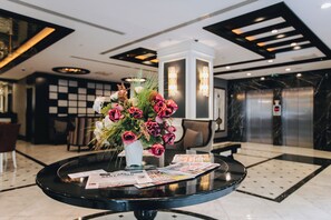 Un mostrador de recepción con un florero, revistas y una decoración de diseño moderno.