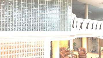 A lobby with a tiled wall, a seating area with leather sofas, and a coffee table.