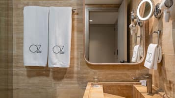 A modern bathroom with two towels hanging on a towel rack, a large mirror, and a sink with a vanity.