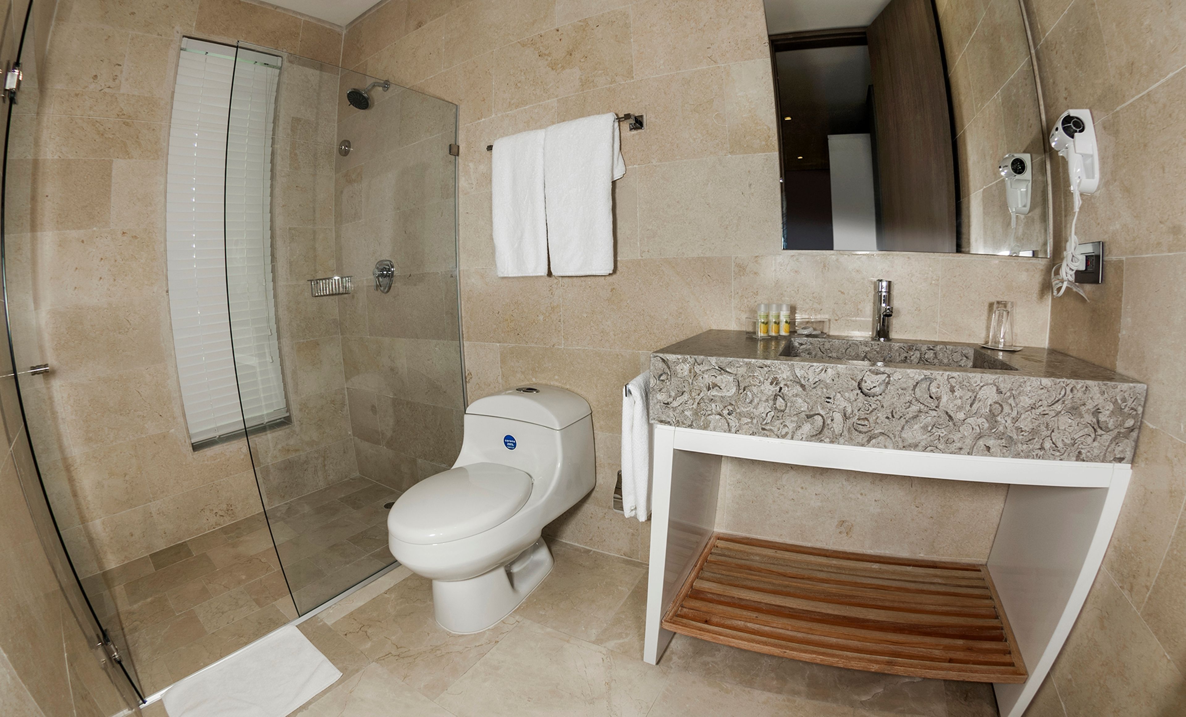 A modern bathroom with a glass-enclosed shower, a toilet, and a vanity with a sink.