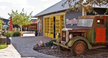 Un coche antiguo estacionado frente a un edificio con un letrero que dice 'Reception'.