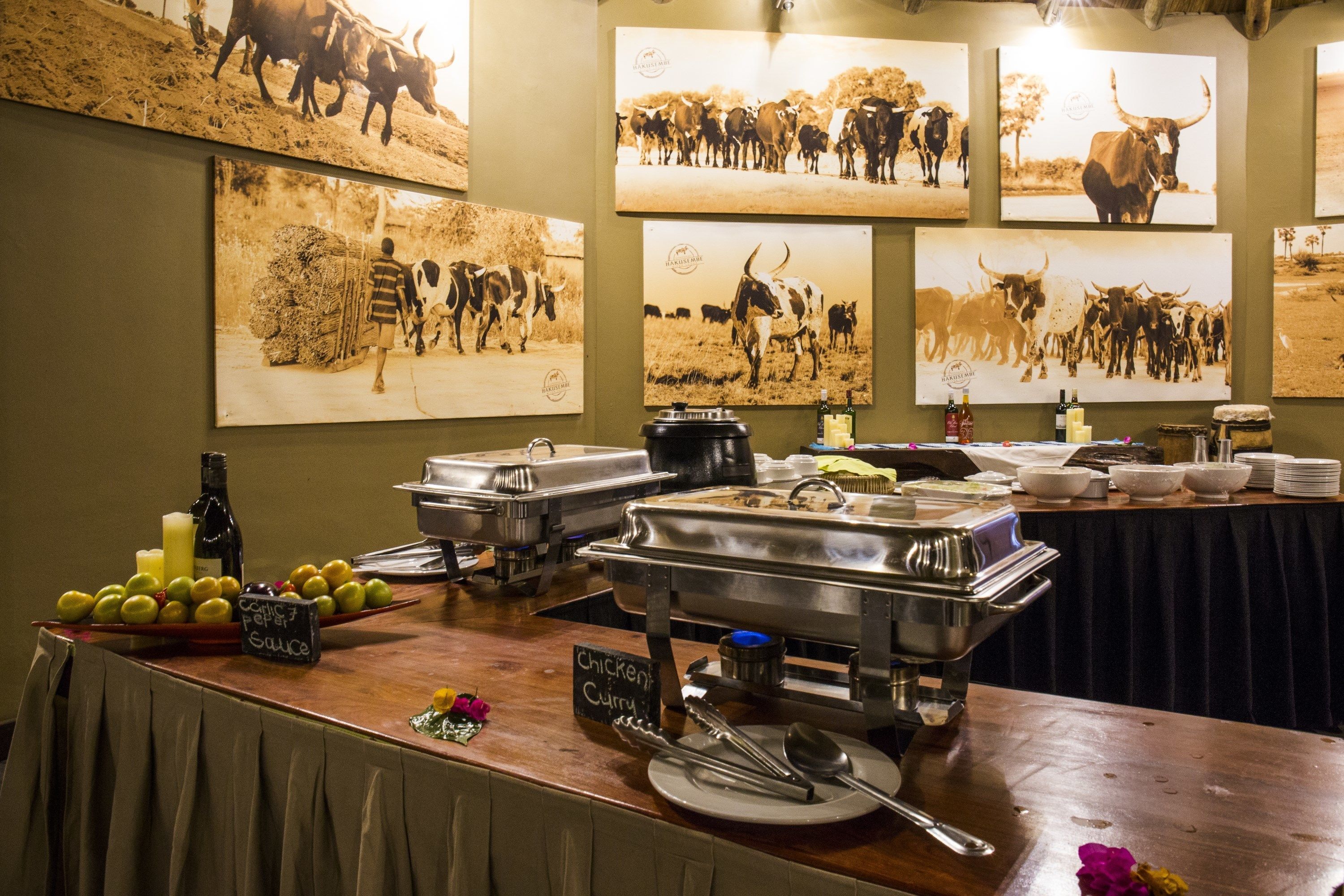 A buffet setup with various food items and condiments, including a sign for 'Chicken Curry'.