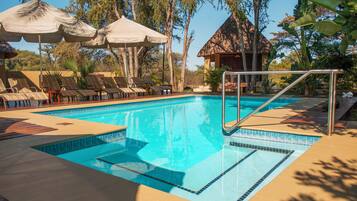 Una piscina al aire libre, tumbonas