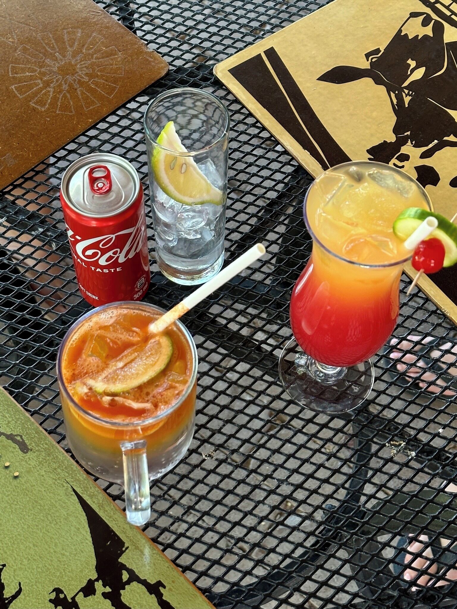 A table with a drink, a can, and a glass of water.