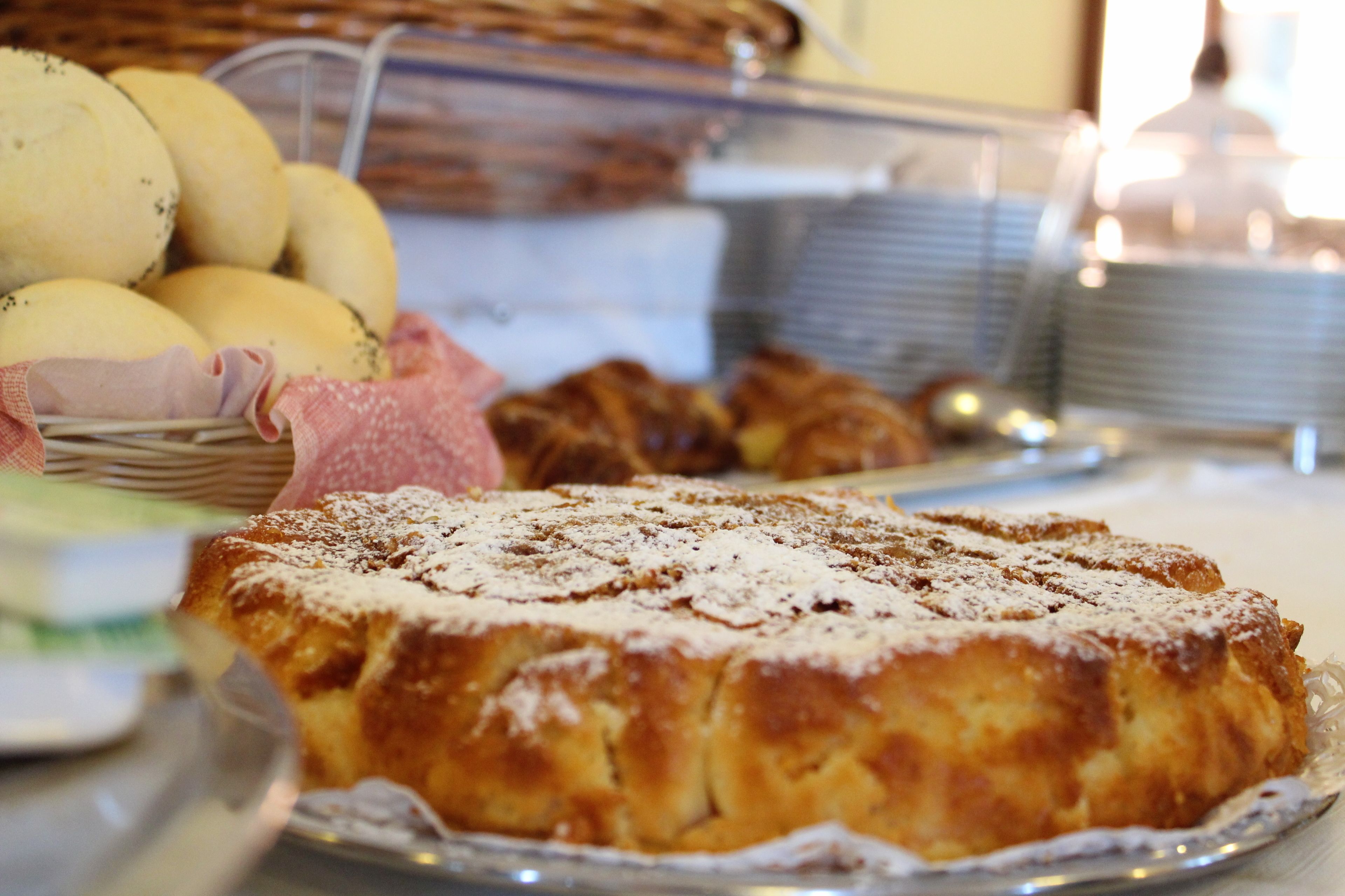 Un bufé de desayuno con diversos pasteles y pan.