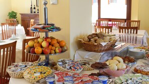 Un bufé con diversos alimentos, como frutas, pastelería y productos lácteos.