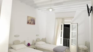 A room with two beds, a desk, and a small table.