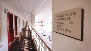 A corridor with a sign indicating rooms 224-236 for vending/ice and rooms 111-124 for the lobby and river access.