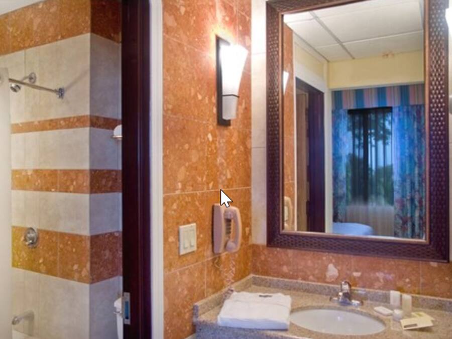 Ein Badezimmer mit Dusche, Waschbecken, Spiegel und Telefon.