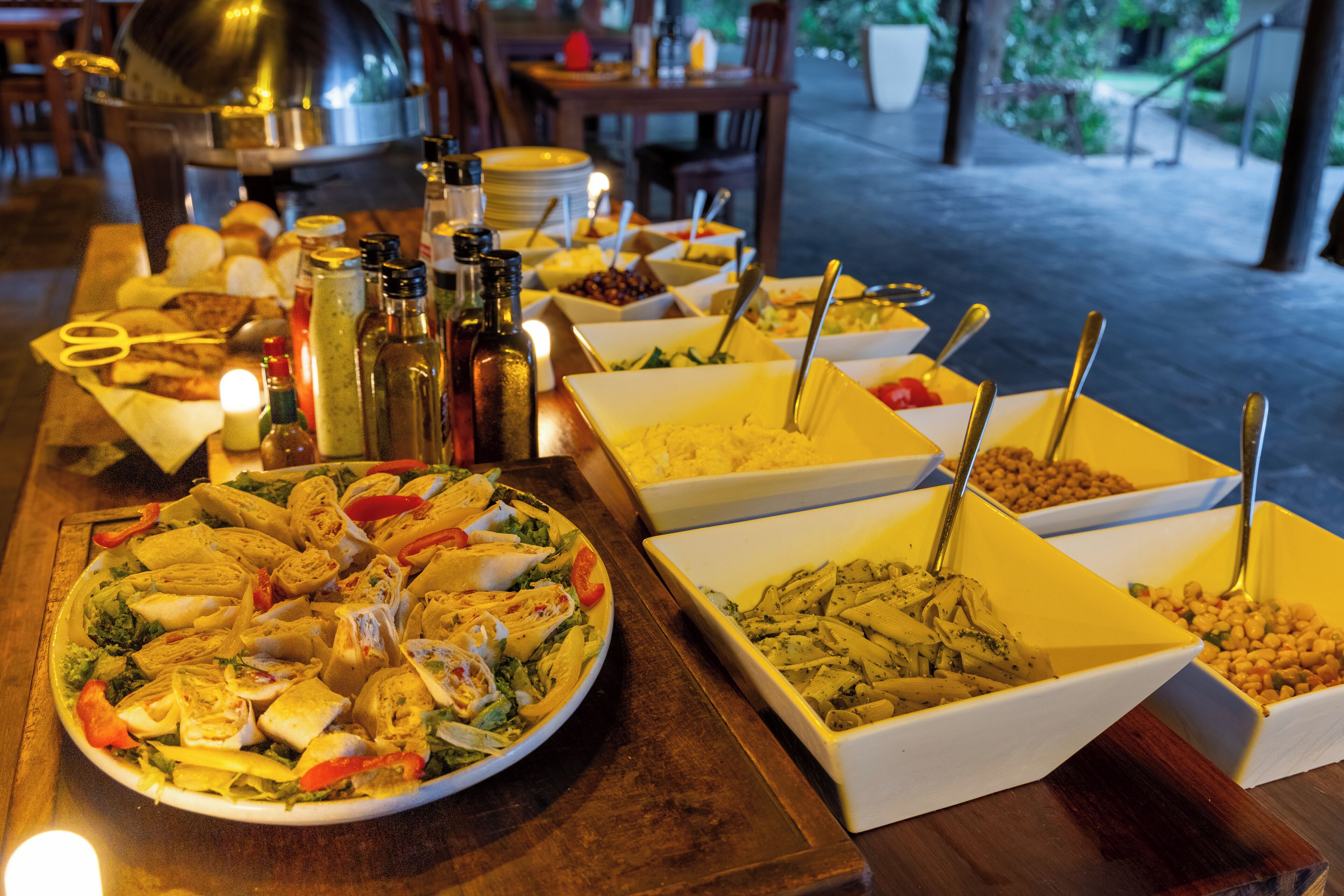 A buffet table with various food items and condiments.