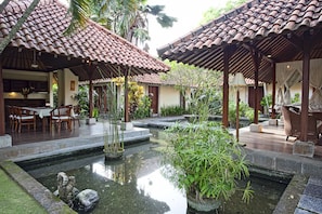 A traditional courtyard with tiled roofs, a central water feature, and outdoor seating.