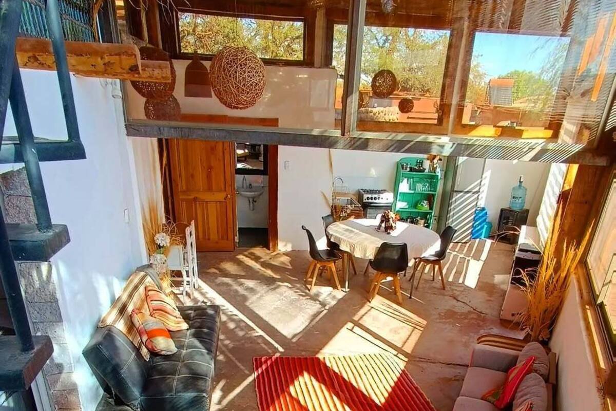 A spacious living area with a high ceiling, a dining table, and a sofa.
