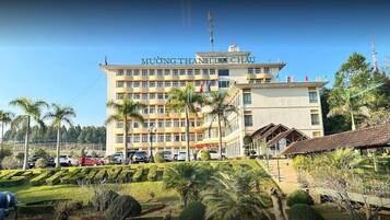 MUÔNG THÀNH HÀ CHAU hotel features a modern design with flat roof and balconies, surrounded by well-maintained gardens and parking.