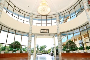 A spacious atrium with a high ceiling, large windows, and a central chandelier. - Muong Thanh Lai Chau Hotel (Lai Chau)