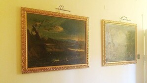Zwei gerahmte Bilder an einer Wand.