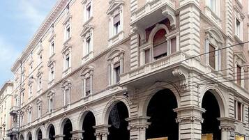 Un edificio storico con numerosi archi e colonne, probabilmente un albergo o un edificio pubblico.