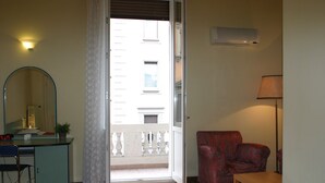 Ein Zimmer mit Schreibtisch, Stuhl und einem roten Sessel.