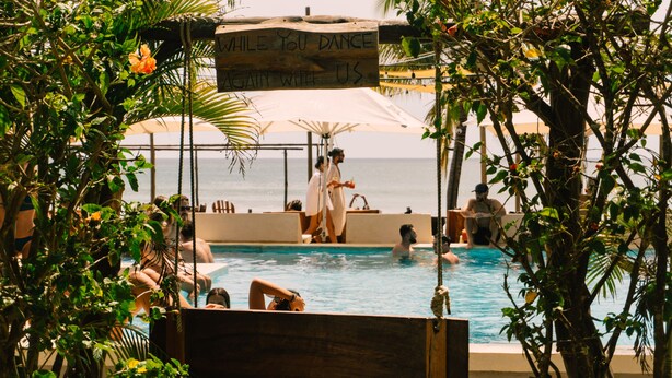 A pool area with a sign that reads "While you dance, we'll again with you."