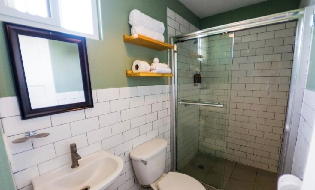 Une salle de bain équipée de toilettes, d’un lavabo et d’une douche à parois en verre.