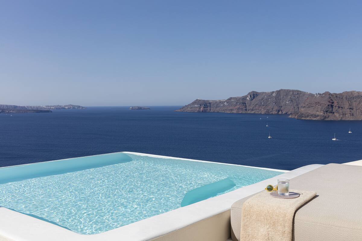 A infinity pool with a clear view of the sea and distant islands.