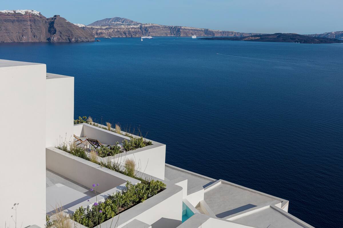 A coastal building with a rooftop garden and a view of the sea.