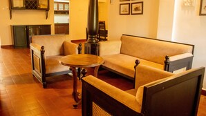 Una sala de estar acogedora con sofá, sillones y una mesa redonda.