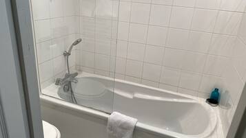 Une salle de bain avec une baignoire, des toilettes et une douche.