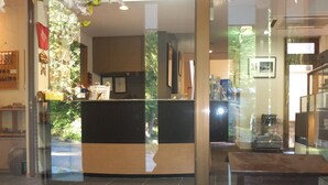 A reception area with a glass door, a wooden bench, and a tiled floor.