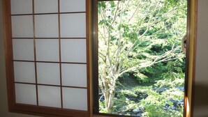 A traditional Japanese shoji screen with a view of a lush garden through a wooden window frame.