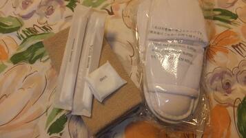 Eine Packung mit Hausschuhen, einer Zahnbürste, einem Zahnbürstenkopf und einer kleinen Packung mit 'deos'.