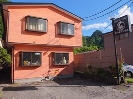 A two-story building with a sign for "Turtle Inn Nikko" and a bicycle parked in front.