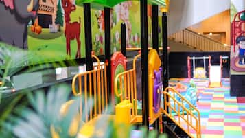 Kids can play and climb in this vibrant indoor play area with a slide, climbing wall, and netted platform.