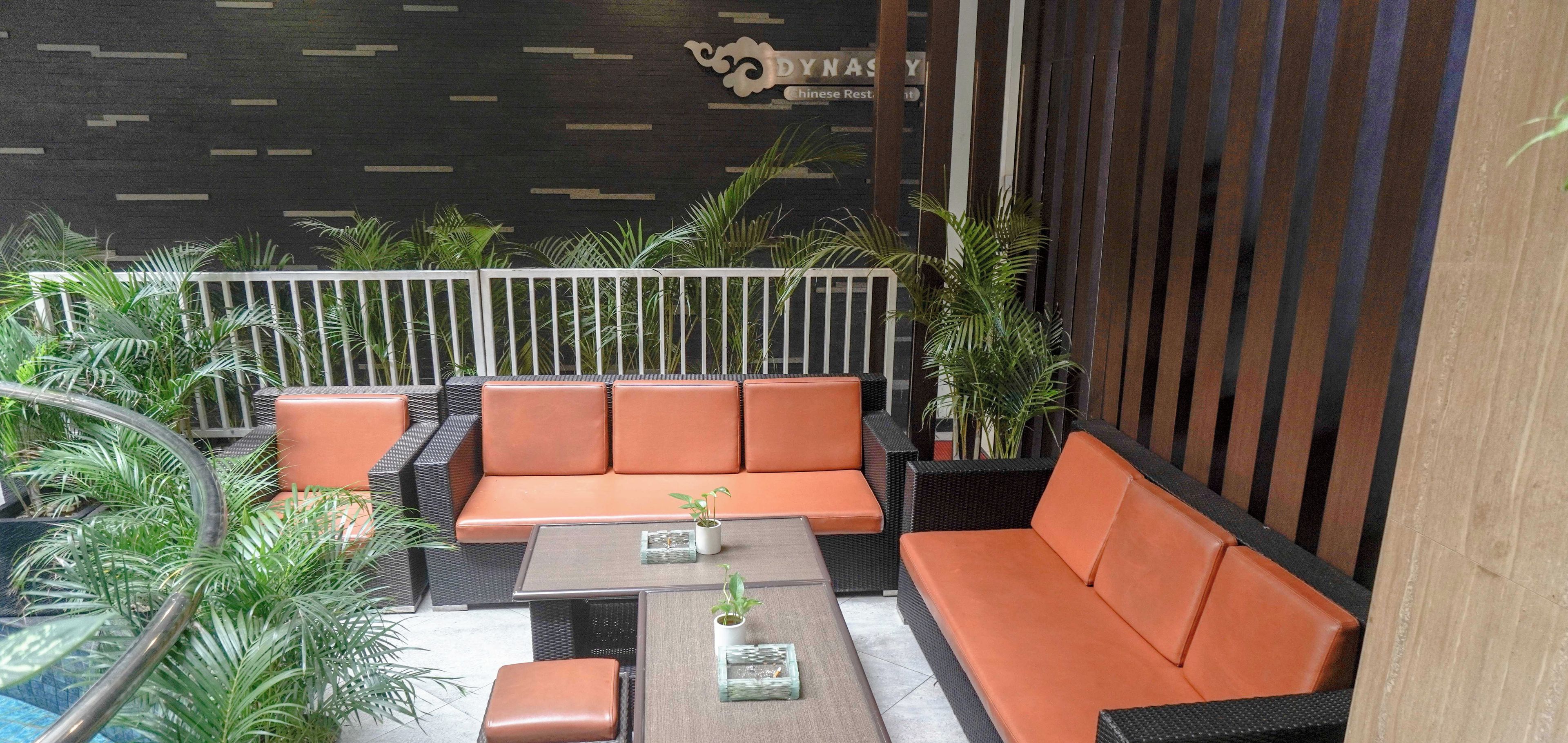 A smoking area with wicker furniture and potted plants.