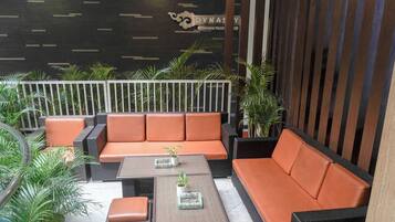 A smoking area with wicker furniture and potted plants.