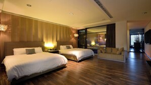 Ein modernes Hotelzimmer mit zwei Betten, einem Schlafsofa und einem großen Fenster mit Blick auf die Stadt.