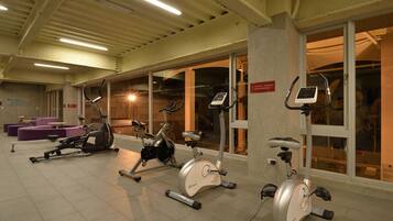 A gym with stationary bikes, a treadmill, and a rowing machine.