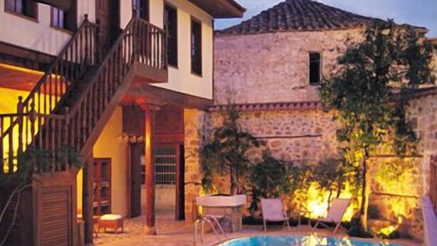 A pool area with lounge chairs and a staircase leading to a building. - Tekeli Konakları (Antalya)