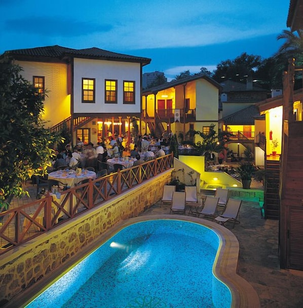 Una piscina al aire libre de temporada, sombrillas, tumbonas