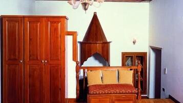 Un dormitorio con una cama grande, un armario de madera y un techo decorativo.