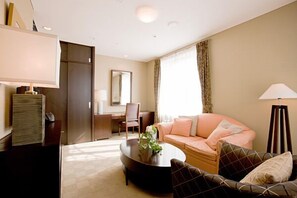 A modern living room with a sofa, armchair, coffee table, and a desk with a chair. - Hotel Kitano Plaza Rokkoso (Kobe)